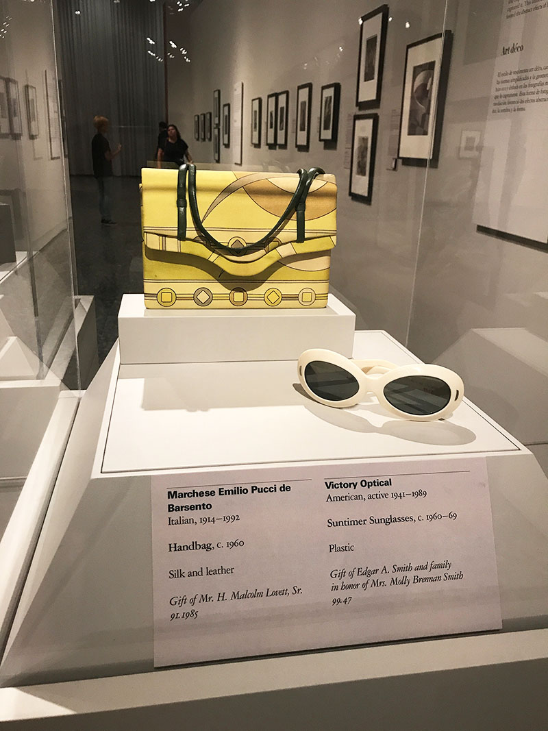 Visitors take photos of a suitcase on display during the Louis