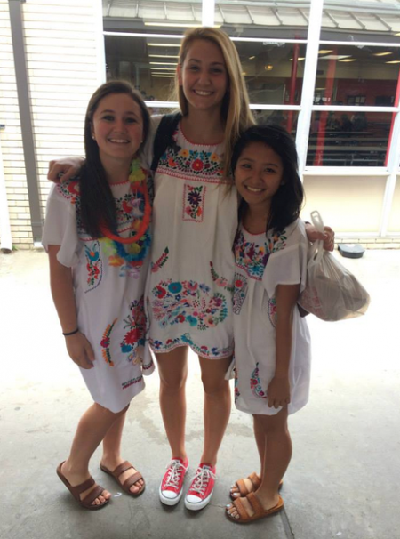 Friends Kelsey Cloud, Nancy Nguyen, and Maddie Tebbe, all seniors, smile for a group picture before a fiesta pep rally.