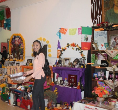 Britnee Chuor makes her way to the kitchen after admiring the altars honoring the past. 