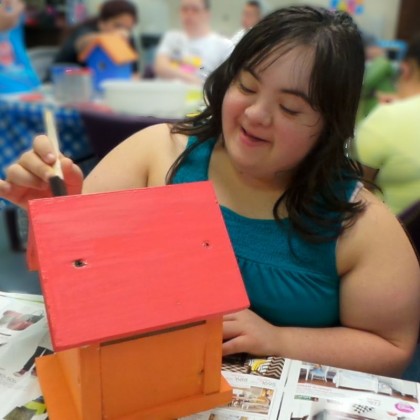Gwendolyn Friedman painting a birdhouse on vocational day at Down Syndrome Academy 