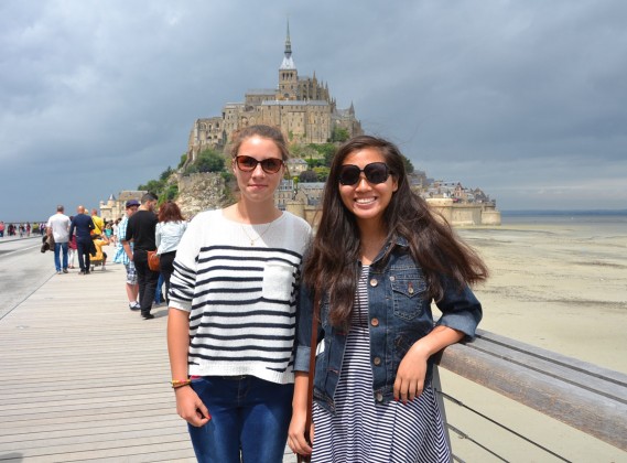 Emma and Ashley Truong pose in front of the Island of Mont Saint Michel.
