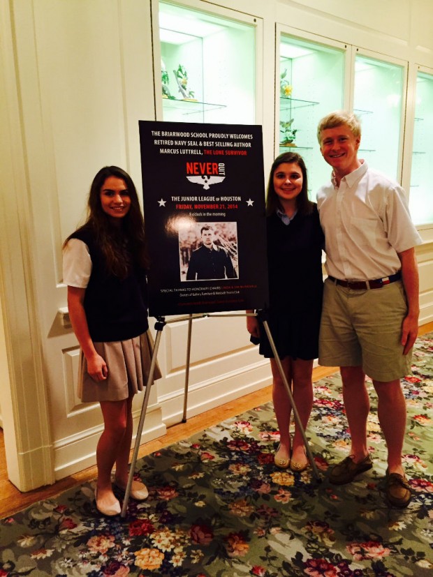 (From left) seniors Katya Gustafson, Emily Hallmark and Ross Ackerman smile for a picture next to the sign announcing Marcus Luttrell’s speech.