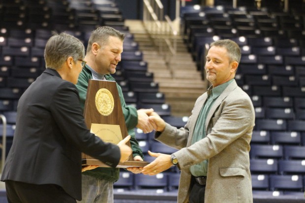 Head Cross Country Coach, Tony Brillon, accepts the state trophy from Athletic Director, Elliot Allen and Executive Director of Athletics, Paige Hershey. This is the second state trophy the cross country runners have been awarded. (Photo: Rebecca Williams