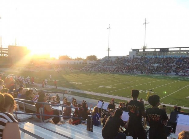 The sun sets behind the field as the game gets started.