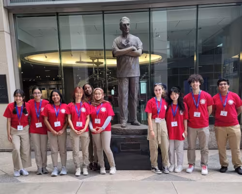 DeBakey students near statue of DeBakey
