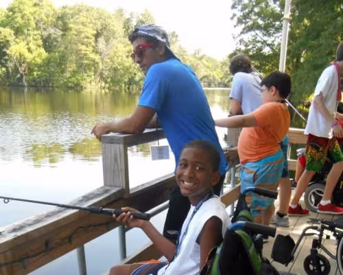 Camper B.J. Bond fishing with his counselor. (Photo provided by MDA Houston Goodwill Ambassadors)